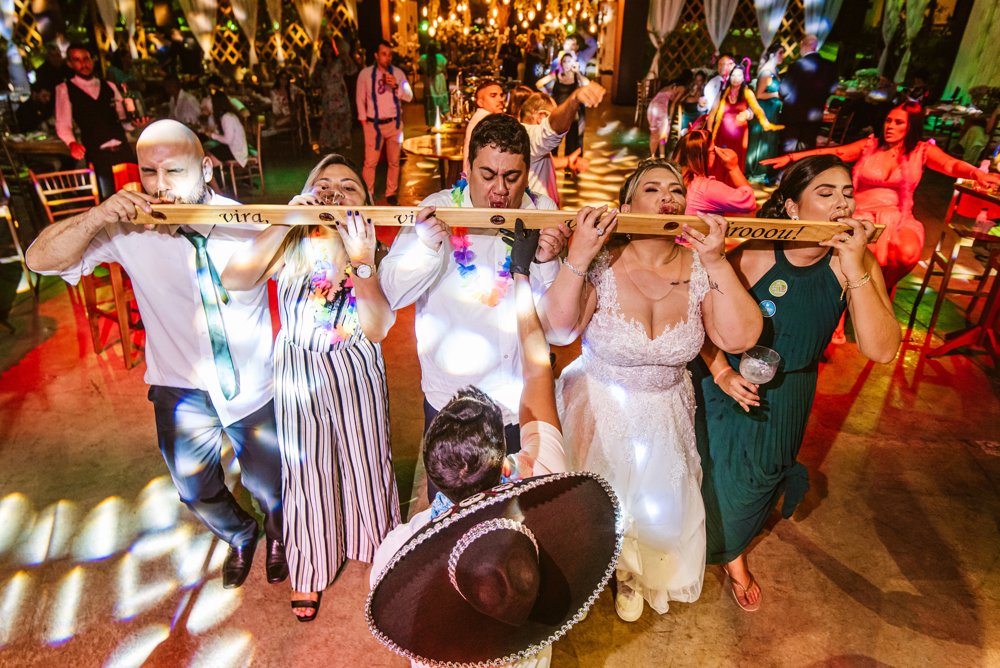 Convidados virando a régua de shots na pista de dança