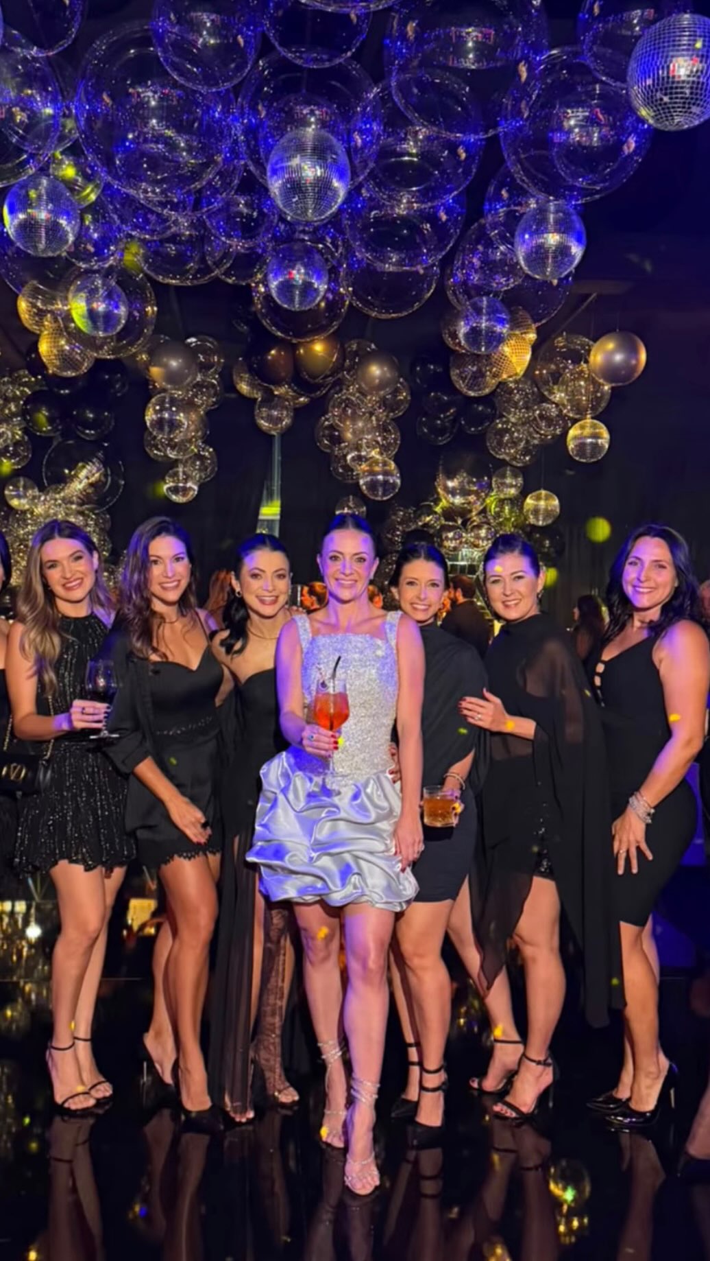 Convidadas em festa com bolas de espelho no teto