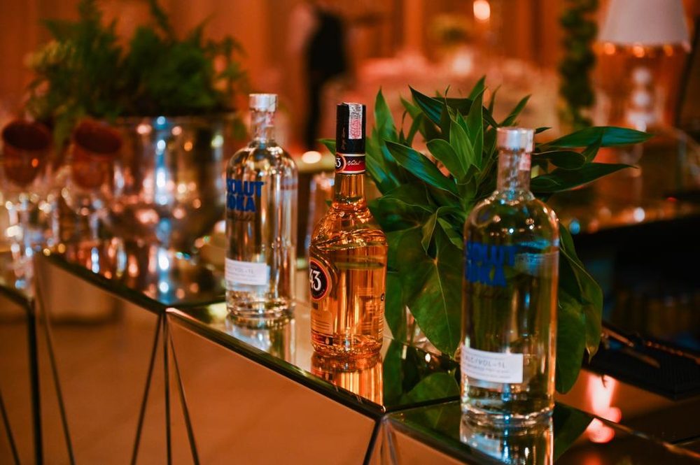 Garrafas de vodka e licor sobre o balcão espelhado do bar