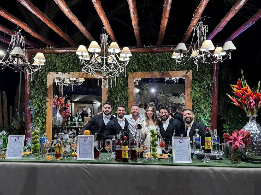 Equipe de barmans atrás do bar montado em festa ao ar livre